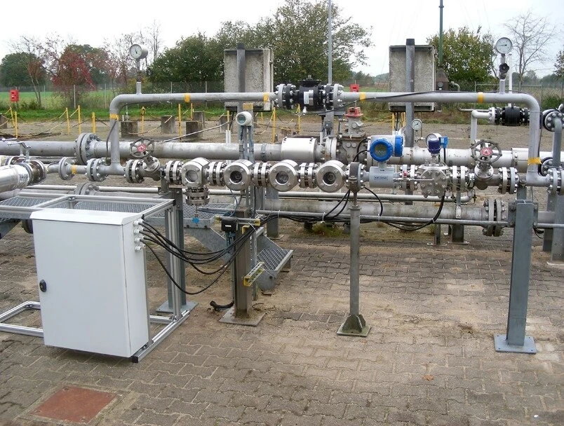 Pipeline-System mit Ventilen und Steuerungseinheit, umgeben von einer industriellen Umgebung.