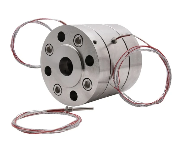 Ein metallisches Bauteil mit runder Form, mehreren Bohrungen und angeschlossenen Drähten. Es könnte sich um einen Sensor oder eine Verbindungseinheit handeln.