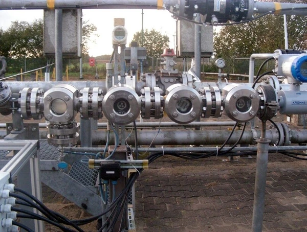 Eine Reihe von Rohrverbindungen mit Messgeräten und Sensoren in industrieller Umgebung.