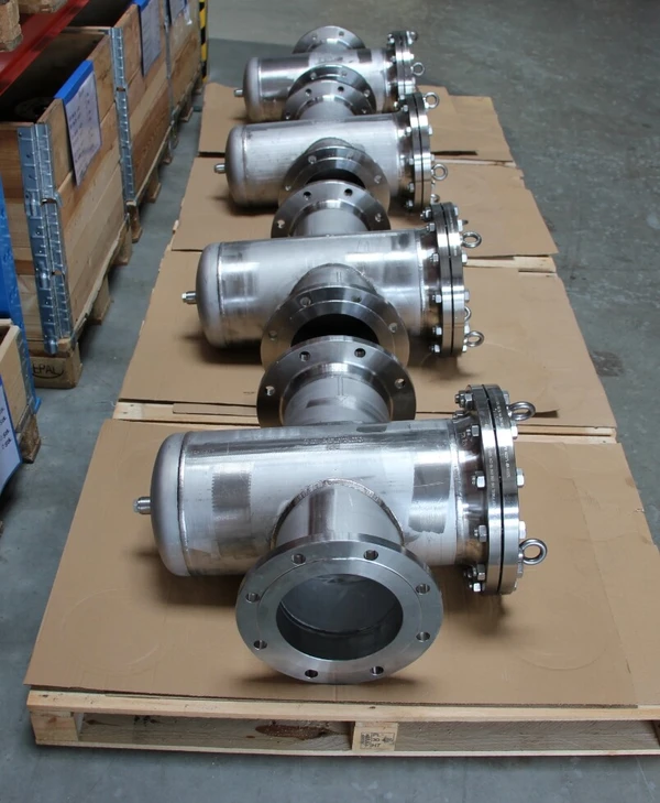 Fünf Edelstahl-Rohre auf Kartons lagern in einem Lager.