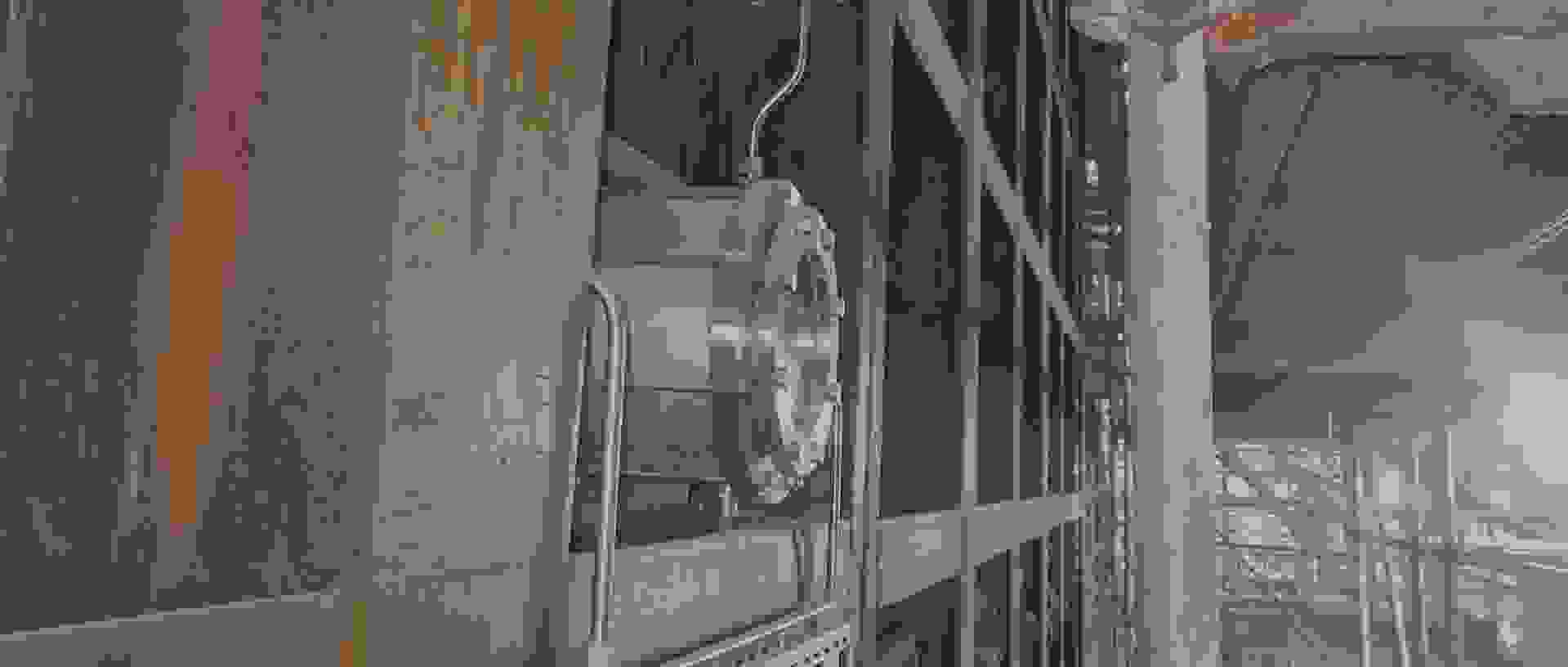 An industrial infrastructure with a metallic pipe and rusty walls in a construction or factory site.