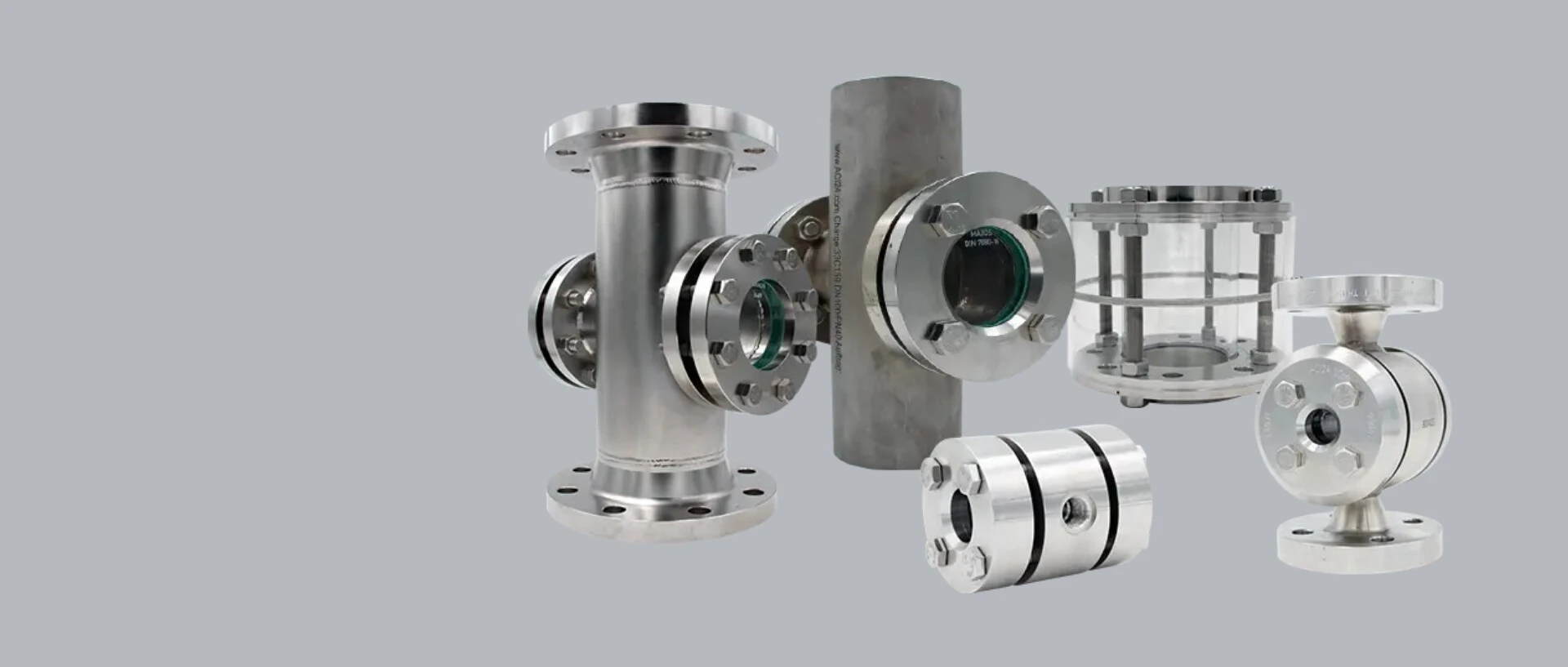 Various industrial stainless steel valves and components on a gray background.