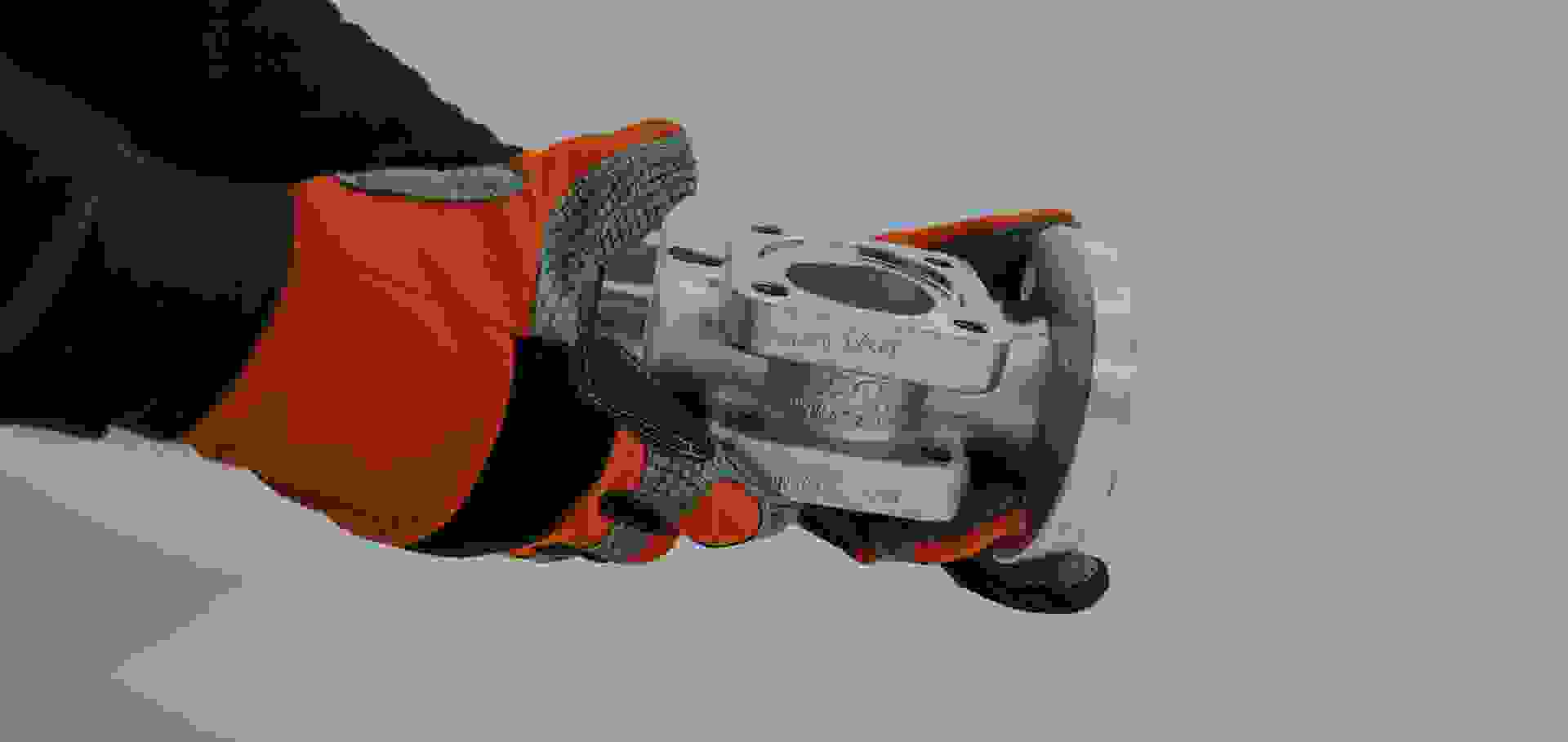 Someone is holding a custom-made fitting from ACI in their hands, wearing gloves.