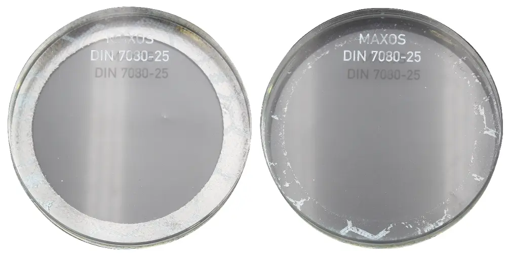 Two circular glass plates with the inscription 'MAXOS' and 'DIN 7080-25', one is clear and the other is slightly scratched.