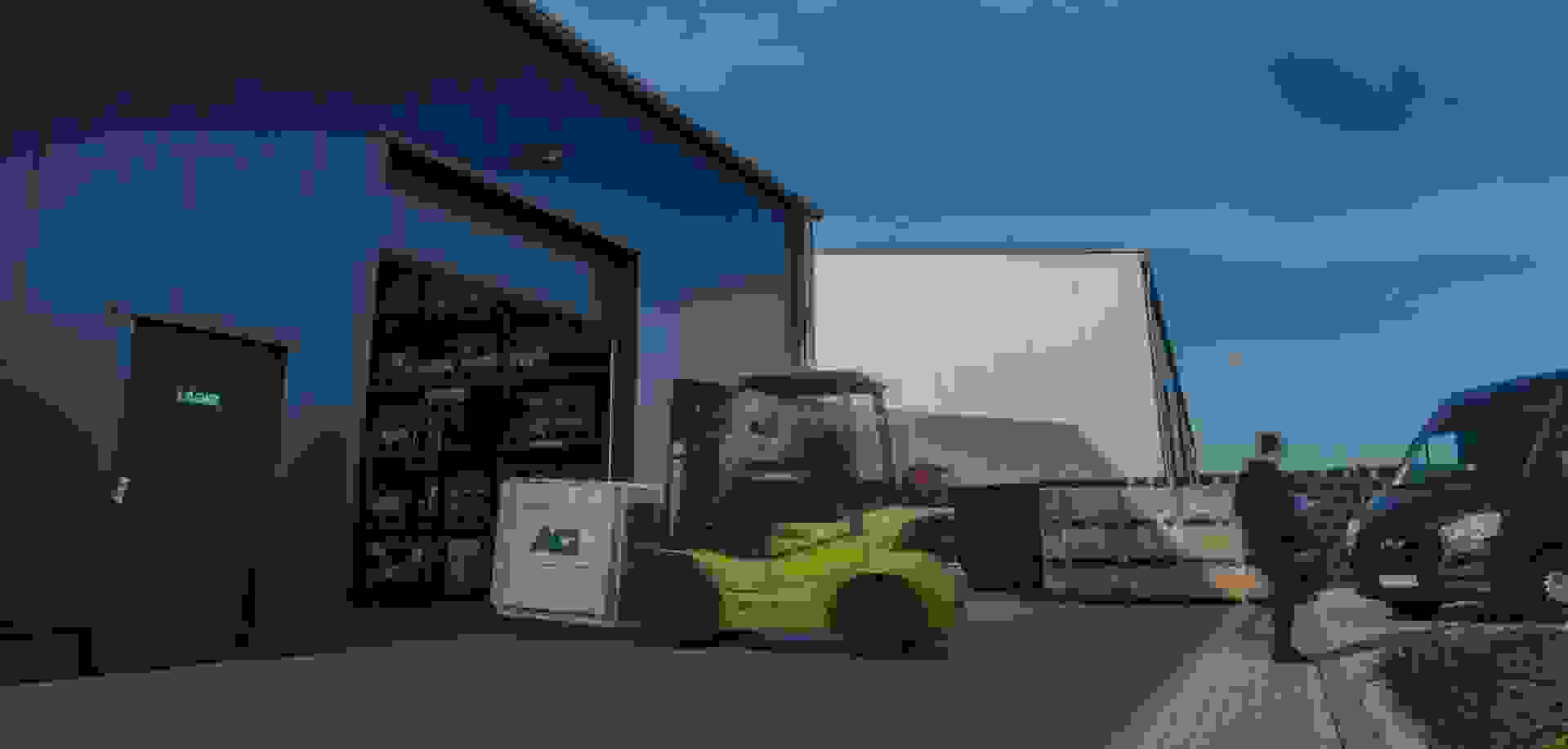 A forklift is moving a pallet into the warehouse.