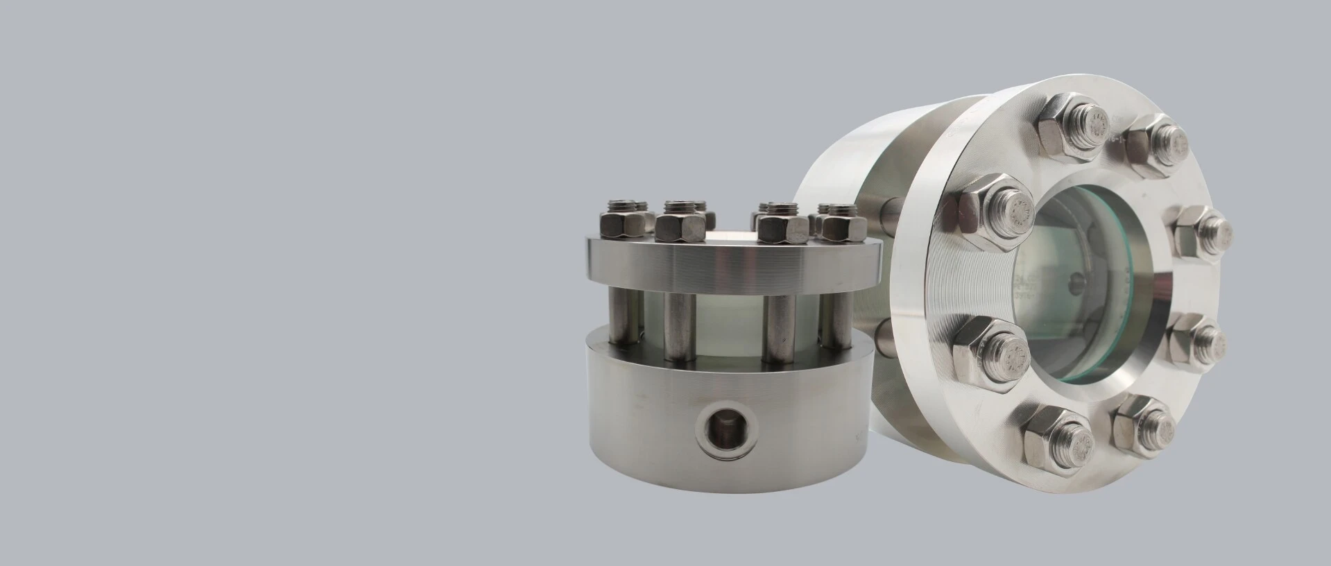 Two stainless steel flanges, one with a sight glass and the other with bolts.