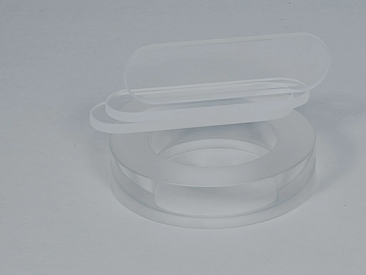 A transparent, round dish with two flat, clear lids.