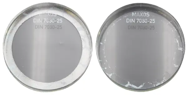 Two circular glass plates with the inscription 'MAXOS' and 'DIN 7080-25', one is clear and the other is slightly scratched.