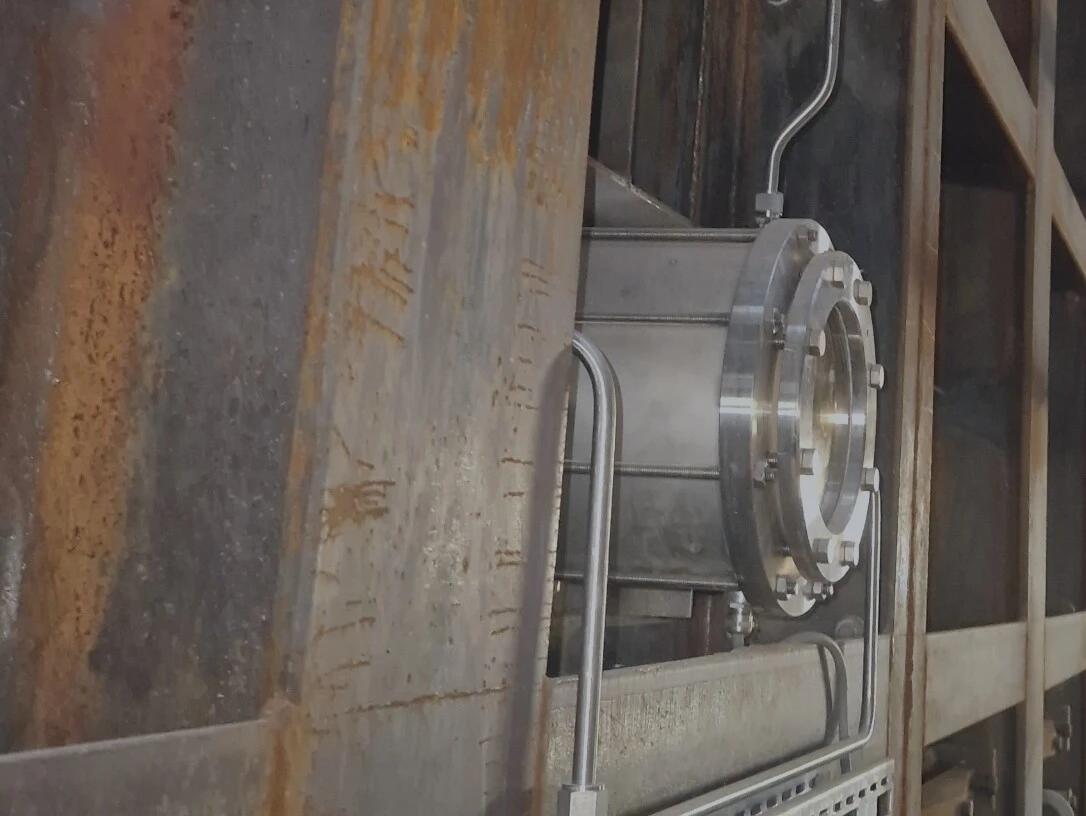 Une infrastructure industrielle avec un tuyau métallique et des murs rouillés sur un chantier ou dans une usine.