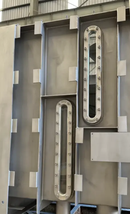 Metalen structuur met twee ovale ramen, die met bouten bevestigd zijn.