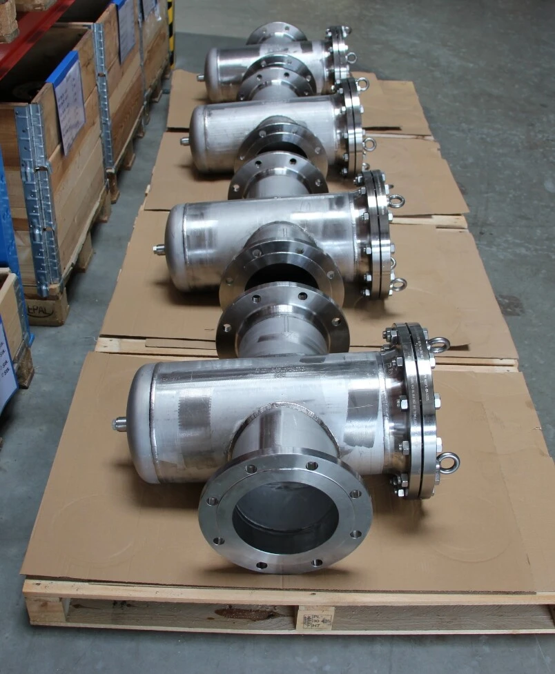 Vijf roestvrijstalen buizen liggen op kartons opgeslagen in een magazijn.