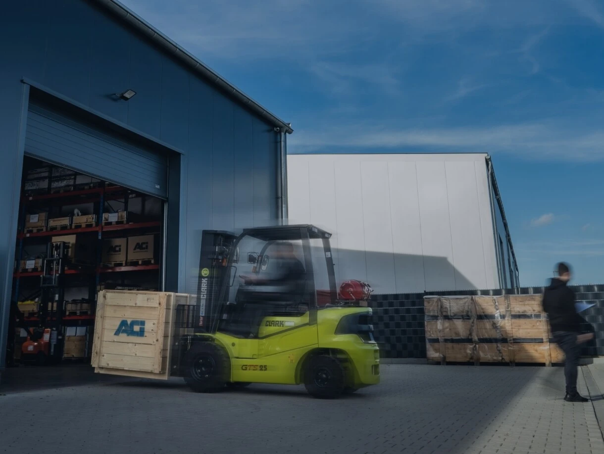 Een heftruck rijdt een pallet het magazijn in.