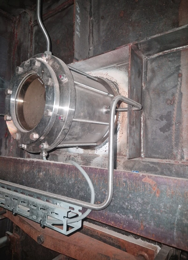 Roestvrijstalen buis met aansluitleidingen, gemonteerd op een metalen constructie.