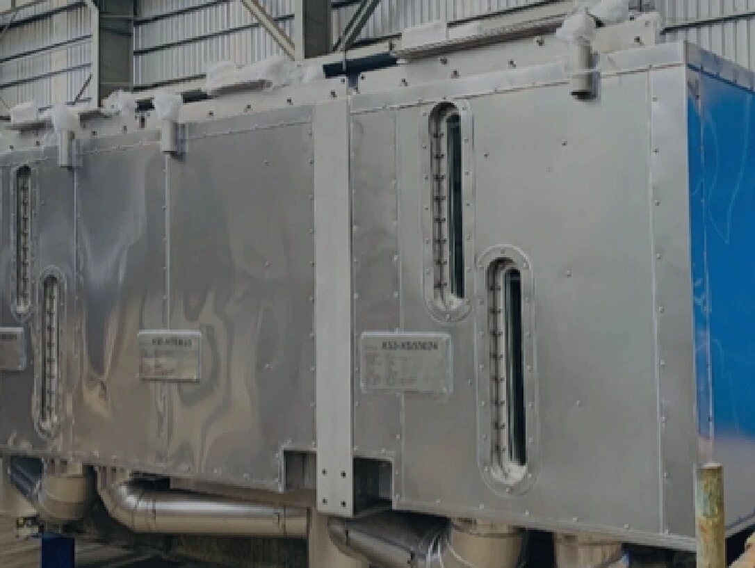 Een grote, glanzende metalen constructie met buizen die in een opslagruimte staat.